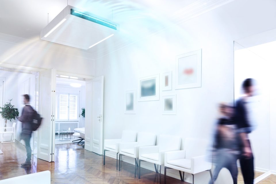 Bright waiting area with white armchairs; a ProCair air disinfection unit with integrated lighting hangs from the ceiling